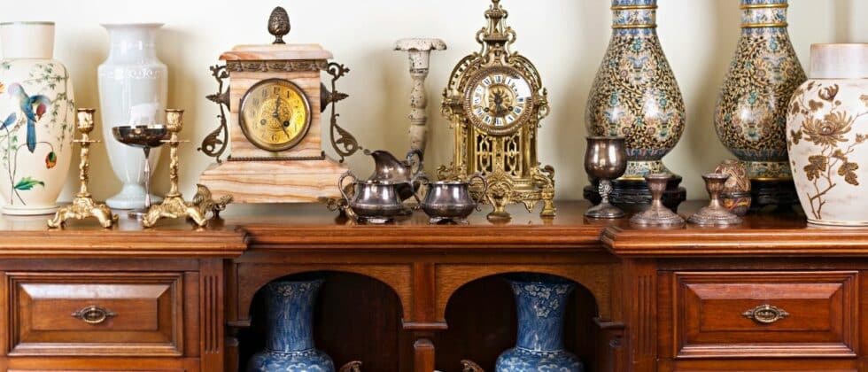 antique clocks and vases on an antique table in a shop