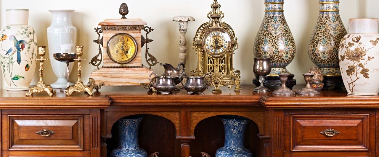 antique clocks and vases on an antique table in a shop